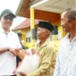 Bupati Solok Selatan Khairunas menyerahkan bantuan beras kepada warga, Minggu (8/9/2024). (Foto: IST)