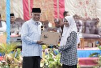 Gubernur Sumbar Mahyeldi menyerahkan hadiah laptop kepada siswi SMAN 1 Solok. (Foto: ADPSB)