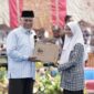 Gubernur Sumbar Mahyeldi menyerahkan hadiah laptop kepada siswi SMAN 1 Solok. (Foto: ADPSB)