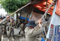 Personil Satpol PP Kota Padang menertibkan bangunan liar di kawasan Pasar Tabing, Kecamatan Koto Tangah, Kamis (26/9/2024). (Foto: Humas Satpol PP Padang)