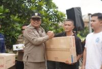 Sekdakab Solsel Syamsurizaldi menyerahkan bantuan peralatan kepada pelaku UMKM. (Foto: Pemkab Solsel)