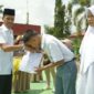 Wakil Bupati Solsel Yulian Efi menyerahkan seragam sekolah kepada siswa di SMAN 5 Solok Selatan. (Foto: Pemkab Solsel)