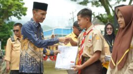 Wakil Bupati Solok Selatan, Yulian Efi menyerahkan seragam sekolah kepada siswa. (Foto: Pemkab Solsel)