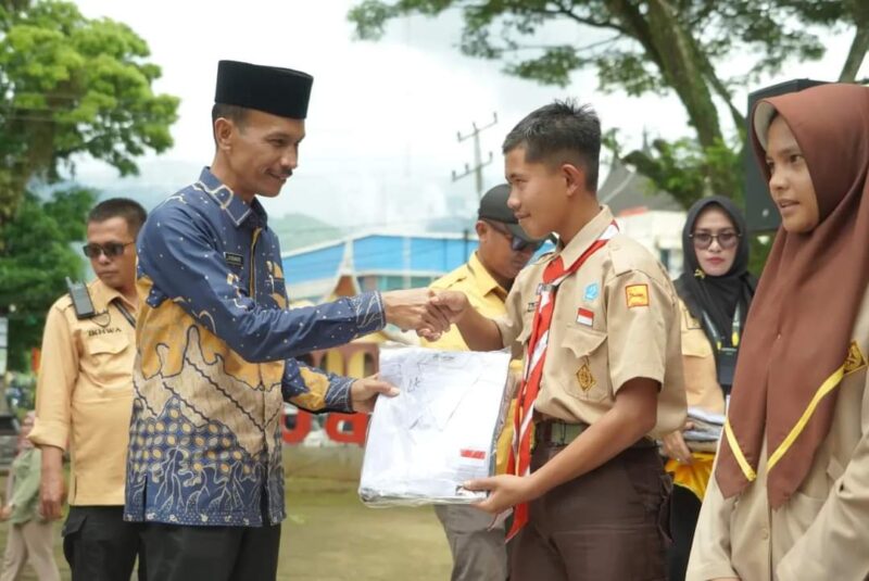 Wakil Bupati Solok Selatan, Yulian Efi menyerahkan seragam sekolah kepada siswa. (Foto: Pemkab Solsel)