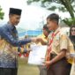 Wakil Bupati Solok Selatan, Yulian Efi menyerahkan seragam sekolah kepada siswa. (Foto: Pemkab Solsel)