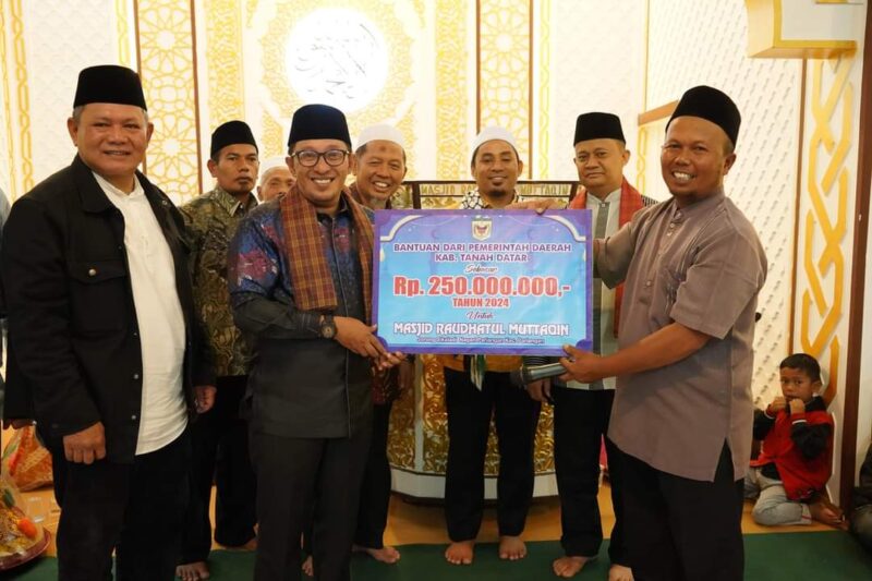 Bupati Eka Putra menyerahkan bantuan dana untuk Masjid Raudhatul Muttaqim. (Foto: Prokopim Tanah Datar)