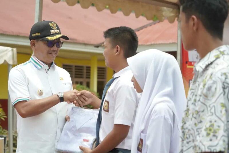 Bupati Solsel Khairunas menyerahkan seragam sekolah kepada siswa. (Foto: Prokopim Solsel)