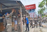 Petugas Satpol PP Padang melakukan pembongkaran lapak PKL yang menggunakan fasilitas umum di Jalan Khatib Sulaiman, Kamis (17/10/2024). (Foto: Humas Satpol PP Padang)