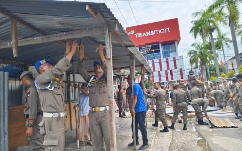 Petugas Satpol PP Padang melakukan pembongkaran lapak PKL yang menggunakan fasilitas umum di Jalan Khatib Sulaiman, Kamis (17/10/2024). (Foto: Humas Satpol PP Padang)