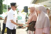 Pjs Bupati Solsel Adib Alfikri menyerahkan bantuan pangan tahap ketiga dari Badan Pangan Nasional kepada KPM. (Foto: Pemkab Solsel)