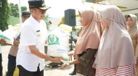 Pjs Bupati Solsel Adib Alfikri menyerahkan bantuan pangan tahap ketiga dari Badan Pangan Nasional kepada KPM. (Foto: Pemkab Solsel)
