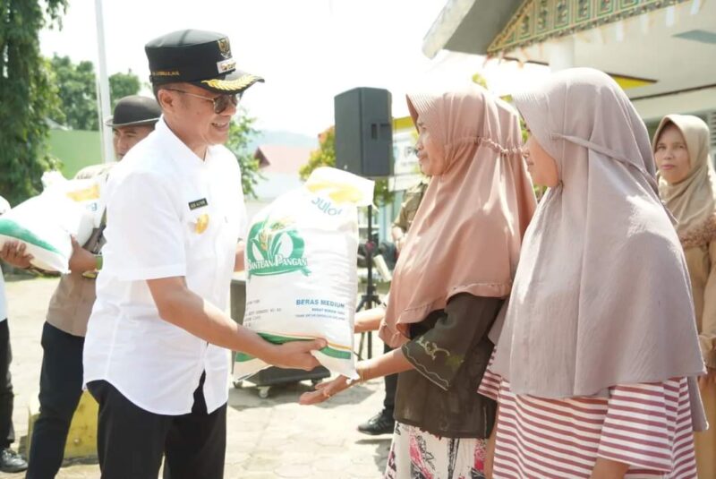 Pjs Bupati Solsel Adib Alfikri menyerahkan bantuan pangan tahap ketiga dari Badan Pangan Nasional kepada KPM. (Foto: Pemkab Solsel)