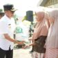 Pjs Bupati Solsel Adib Alfikri menyerahkan bantuan pangan tahap ketiga dari Badan Pangan Nasional kepada KPM. (Foto: Pemkab Solsel)