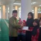 Kabag Kesra Setdako Padang Jasman menyerahkan santunan secara simbolis kepada penerima. (Foto: Diskominfo Padang)
