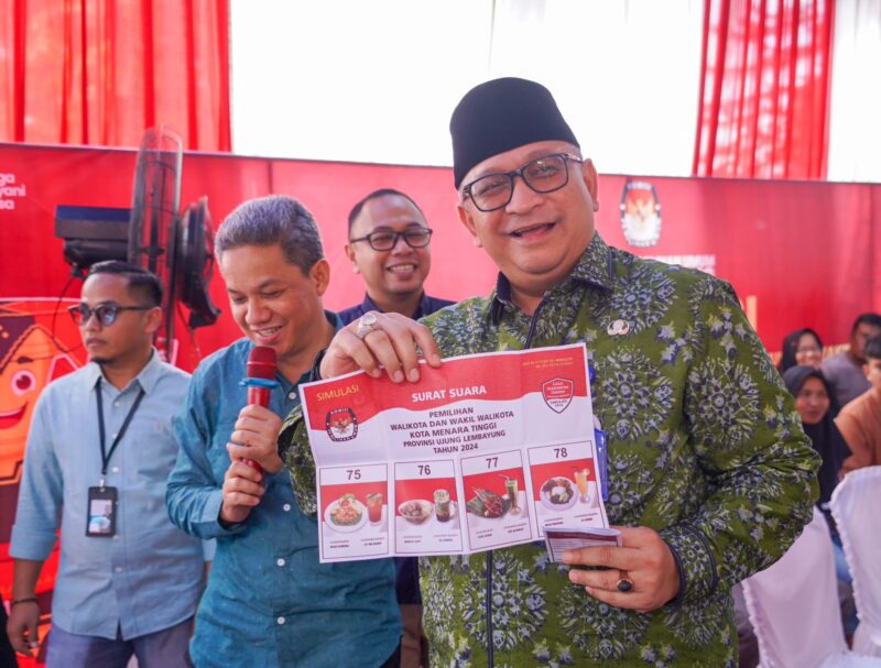 Pj Wali Kota Padang Andree Algamar memperlihatkan surat suara yang digunakan dalam simulasi pemungutan dan penghitungan suara Pilkada serentak, di halaman Kantor Camat Pauh, Kamis (14/11/2024). (Foto: Prokopim Padang)