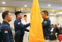 Camat Lubeg Nofiandi Amir menyerahkan pataka Karang Taruna kepada Ketua Karang Taruna Lubeg Zalman Efendi Chaniago yang baru saja dikukuhkan. (Foto: Ist)