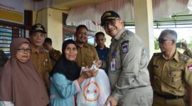Pj Wali Kota Padang Andree Algamar menyerahkan secara simbolis bantuan pangan beras kepada warga. (Foto: Prokopim Padang)