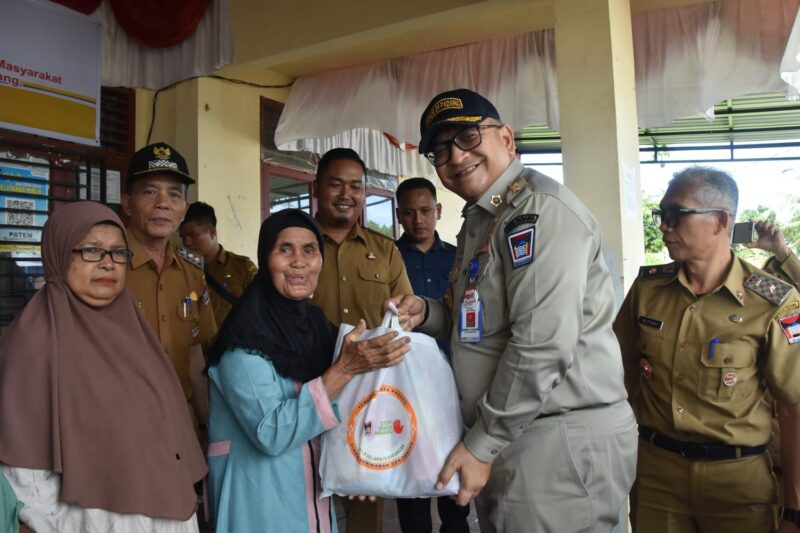 Pj Wali Kota Padang Andree Algamar menyerahkan secara simbolis bantuan pangan beras kepada warga. (Foto: Prokopim Padang)