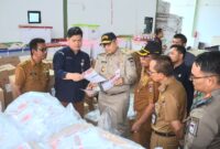 Penjabat (Pj) Wali Kota Padang, Andree Algamar meninjau proses penyortiran dan pelipatan surat suara Pilkada 2024 di Gudang Logistik KPU Padang, Selasa (5/11/2024). (Foto: Prokopim Padang)
