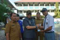 Pj Wali Kota Padang Andree Algamar menyerahkan secara simbolis KTP-el kepada siswa SMAN 1 Padang. (Foto: Prokopim Padang)