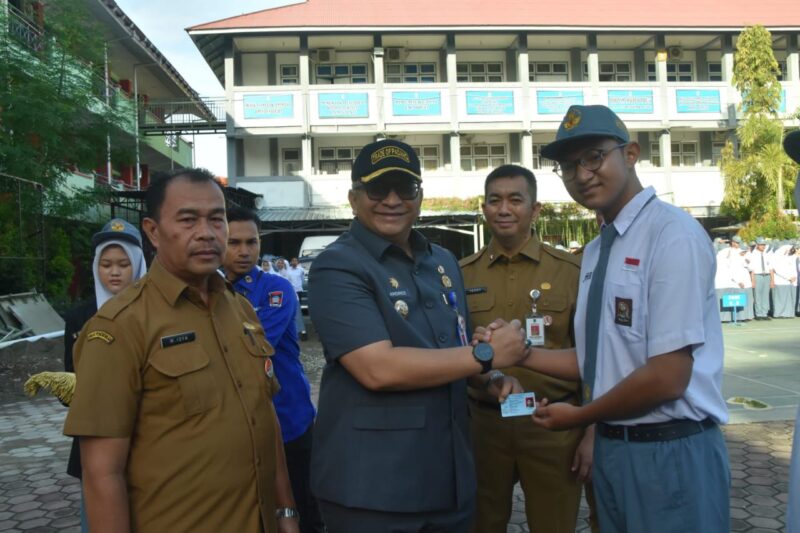 Pj Wali Kota Padang Andree Algamar menyerahkan secara simbolis KTP-el kepada siswa SMAN 1 Padang. (Foto: Prokopim Padang)