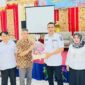 Camat Lubeg Nofiandi Amir menerima bantuan Genting dari perwakilan PT United Tractors Tbk. (Foto: Ist)