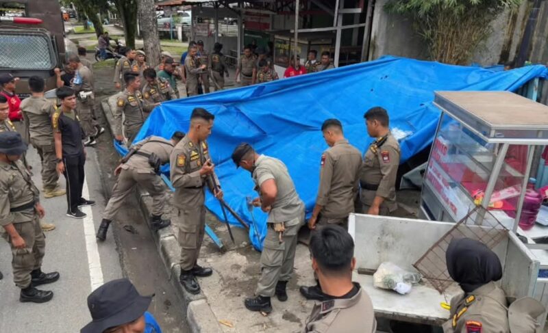 Tim gabungan melakukan penertiban lapak yang berdiri di atas fasilitas umum di sepanjang Jalan Adinegoro, Rabu (4/12/2024). (Foto: Satpol PP Padang)