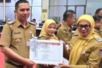 Camat Lubeg Nofiandi Amir menerima piagam penghargaan dari Asisten III Setdako Padang Corri Saidan. (Foto: Ist)