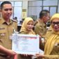 Camat Lubeg Nofiandi Amir menerima piagam penghargaan dari Asisten III Setdako Padang Corri Saidan. (Foto: Ist)