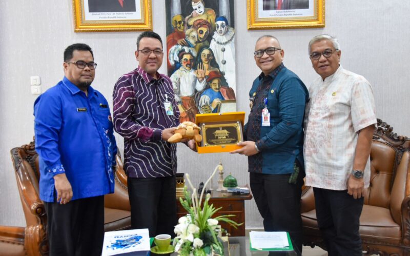 Penjabat (Pj) Wali Kota Padang Andree Algamar menyerahkan cenderamata kepada Kepala BPJS Ketenagakerjaan Cabang Padang Muhammad Syahrul. (Foto: Prokopim Padang)