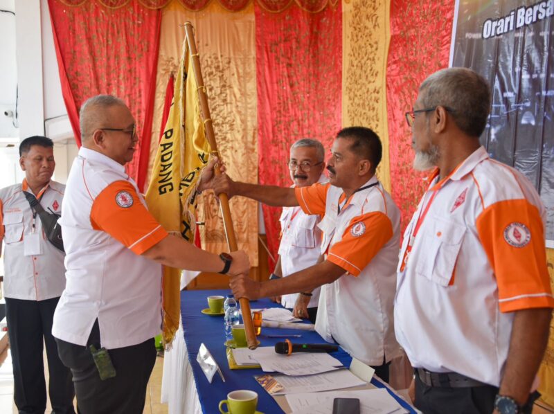Demisioner Ketua ORARI Kota Padang Andree Algamar menyerahkan bendera pataka kepada Pimpinan Sidang Musyawarah ORARI Padang Guswandi. (Foto: Prokopim Padang)