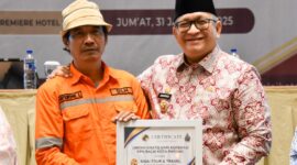 Pj Wali Kota Padang Andree Algamar menyerahkan reward umrah kepada Eferoni Lase. (Foto: Prokopim Padang)