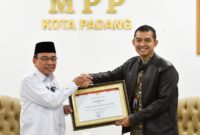 Wawako Padang Maigus Nasir menyerahkan penghargaan Kepala Kantor BPJS Kesehatan Cabang Padang Fauzi Lukman Nurdiansyah, di Gedung MPP Padang Lantai 4 Plaza Andalas, Rabu (26/2). (Foto: Prokopim Padang)