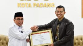 Wawako Padang Maigus Nasir menyerahkan penghargaan Kepala Kantor BPJS Kesehatan Cabang Padang Fauzi Lukman Nurdiansyah, di Gedung MPP Padang Lantai 4 Plaza Andalas, Rabu (26/2). (Foto: Prokopim Padang)