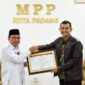 Wawako Padang Maigus Nasir menyerahkan penghargaan Kepala Kantor BPJS Kesehatan Cabang Padang Fauzi Lukman Nurdiansyah, di Gedung MPP Padang Lantai 4 Plaza Andalas, Rabu (26/2). (Foto: Prokopim Padang)