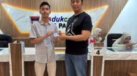Kepala Disdukcapil Padang Teddy Antonius menyerahkan e-KTP kepada warga. (Foto: MC Padang)