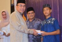 Wawako Padang Maigus Nasir menyerahkan santunan kepada anak yatim saat kegiatan buka puasa yang digelar oleh DPD REI Sumbar. (Foto: Prokopim Padang)