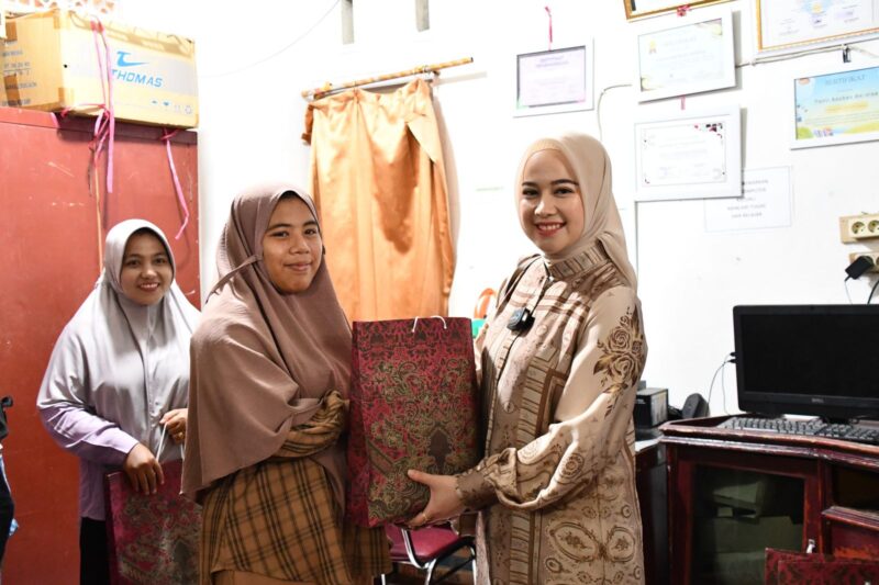 Istri Wali Kota Padang, Ny. Dian Puspita Fadly Amran Sp.JP menyerahkan bingkisan kepada anak panti asuhan. (Foto: Prokopim Padang)