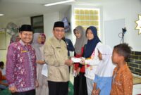 Wakil Wali Kota Padang, Maigus Nasir menyerahkan santunan kepada anak yatim di Masjid Ukhuwah, Komplek Perkantoran Balai Kota Padang, Aie Pacah, pada Jumat (21/3/2025). (Foto: Prokopim Padang)