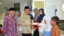 Wakil Wali Kota Padang, Maigus Nasir menyerahkan santunan kepada anak yatim di Masjid Ukhuwah, Komplek Perkantoran Balai Kota Padang, Aie Pacah, pada Jumat (21/3/2025). (Foto: Prokopim Padang)
