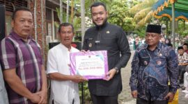 Wali Kota Padang Fadly Amran menyerahkan dana operasional RT/RW secara simbolis di Kecamatan Lubuk Kilangan, Jumat (11/4/2025). (Foto: Prokopim Padang)