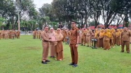 Pj Sekda Sumbar Yozarwardi Usama Putra menyerahkan penghargaan kepada biro terbaik dalam ajang penghargaan internal. (Foto: adpsb)