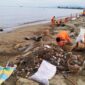 Pasukan Oranye dari DLH Kota Padang bekerja membersihkan tumpukan sampah yang memenuhi Pantai Padang. (Foto: FB Diskominfo Padang)