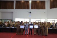Sekda Kota Padang Andree Algamar memberikan penghargaan kepada tiga perangkat daerah terbaik dalam penyampaian laporan dan capaian realisasi fisik dan keuangan tahun 2024, Selasa (29/4/2025). (Foto: Prokopim Padang)