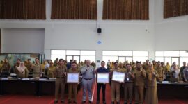 Sekda Kota Padang Andree Algamar memberikan penghargaan kepada tiga perangkat daerah terbaik dalam penyampaian laporan dan capaian realisasi fisik dan keuangan tahun 2024, Selasa (29/4/2025). (Foto: Prokopim Padang)