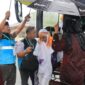 Petugas sigap memayungi Jemaah haji di tengah hujan deras. (Foto: Humas Kemenag Sumbar)