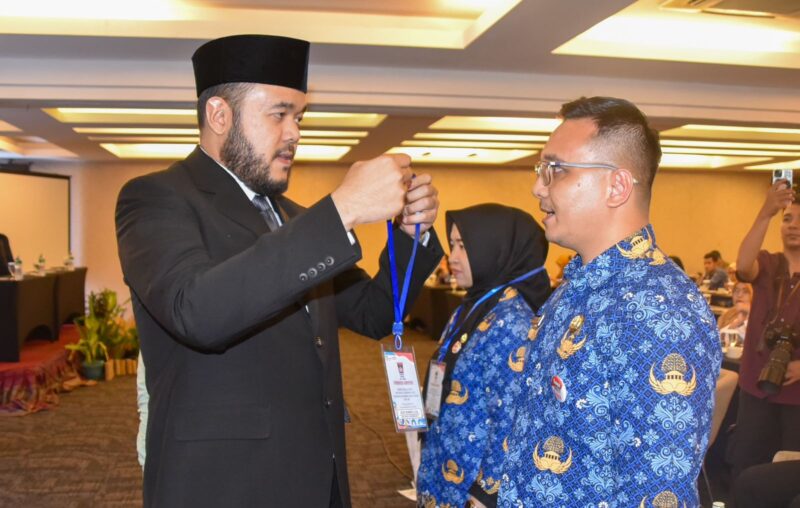 Wali Kota Padang Fadly Amran memasangkan kokarde kepada peserta Bimtek Keprotokolan dan MC ASN di lingkungan Pemko Padang, Selasa (20/5). (Foto: Prokopim Padang)