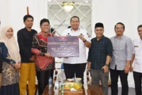 Ketua KPU Kota Pariaman, Ali Unan menyerahkan sisa dana hibah Pilkada kepada Wali Kota Pariaman, Yota Balad, Rabu (28/5/2025). (Foto: Diskominfo Pariaman)