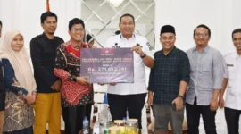 Ketua KPU Kota Pariaman, Ali Unan menyerahkan sisa dana hibah Pilkada kepada Wali Kota Pariaman, Yota Balad, Rabu (28/5/2025). (Foto: Diskominfo Pariaman)