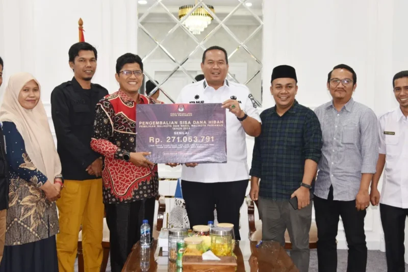 Ketua KPU Kota Pariaman, Ali Unan menyerahkan sisa dana hibah Pilkada kepada Wali Kota Pariaman, Yota Balad, Rabu (28/5/2025). (Foto: Diskominfo Pariaman)